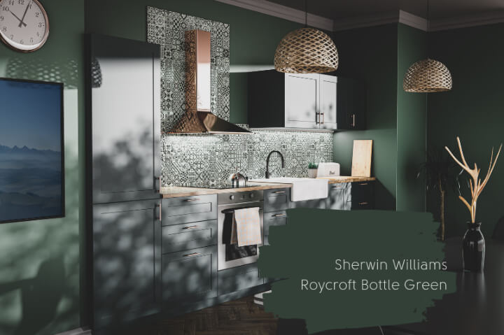 A paint swatch of Roycroft Bottle Green over a kitchen with black cabinets, black and white patterned tile, and dark green walls.