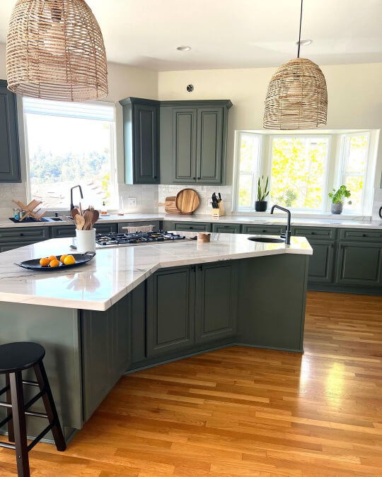 Pewter Green Kitchen cabinets and island with honey oak floors in a bright kitchen with creamy walls
