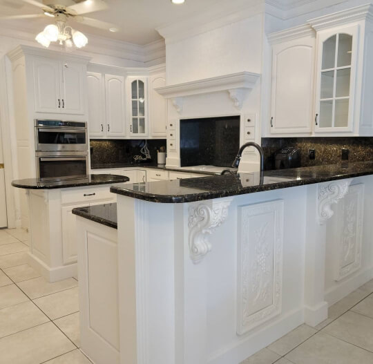 Sherwin WIlliams snowbound on kitchen cabinets with black countertops and white walls