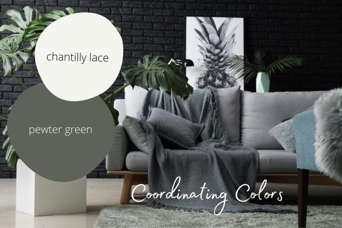 Sample dots of Pewter Green and Chantilly Lace over a living room background with charcoal walls, gray couch, and white accents.