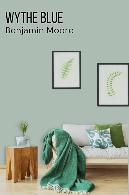 a living room with Wythe Blue by Benjamin Moore on the wall behind a beige couch.