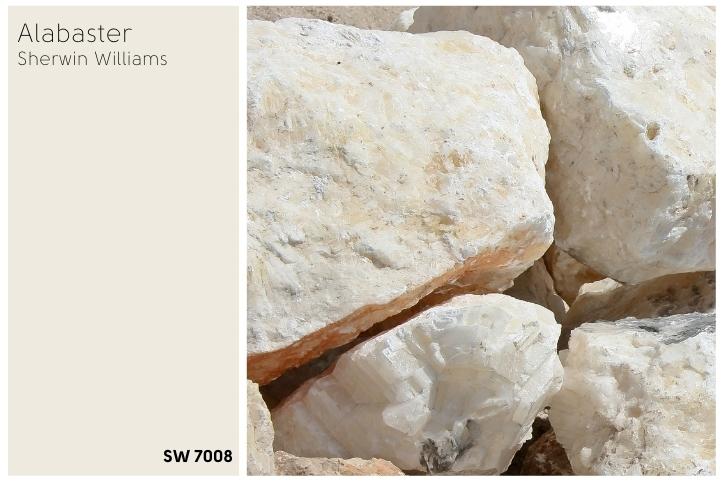 A swatch of the color Alabaster by Sherwin Williams beside a pile of alabaster rocks.