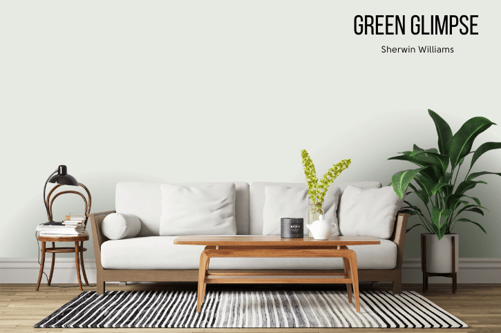 Sherwin Williams Green Glimps - a very light gray green - on a living room wall behind a white canvas sofa