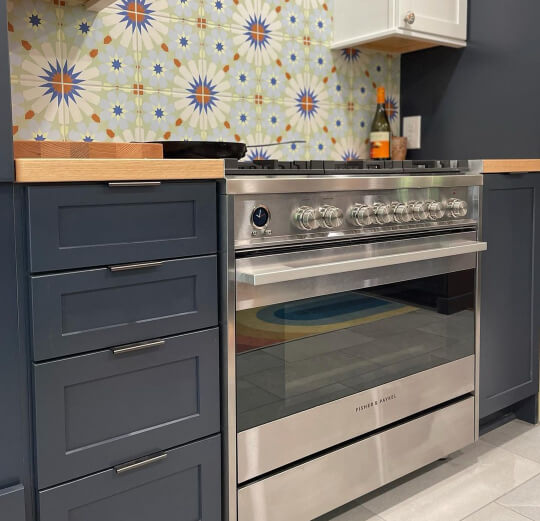 Navy Blue kitchen cabinets, butcher block counters and patterned tile