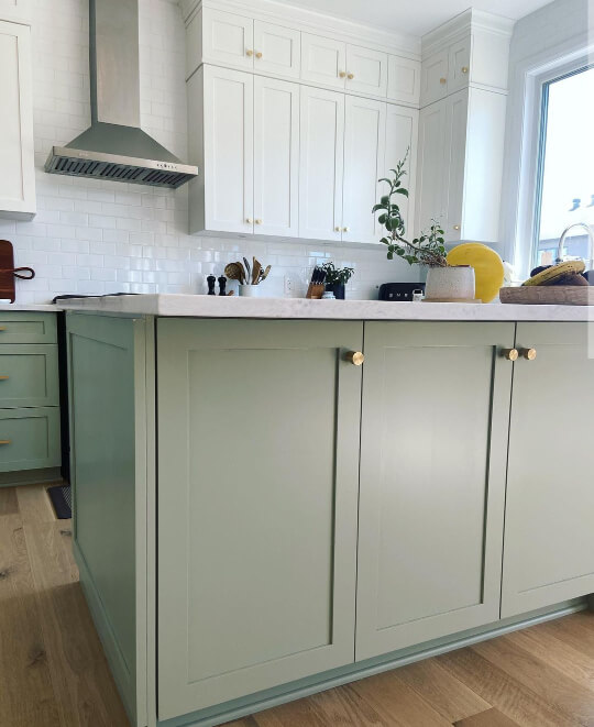 Saybrook Sage lower cabinets and island with white upper cabinets in a two toned kitchen