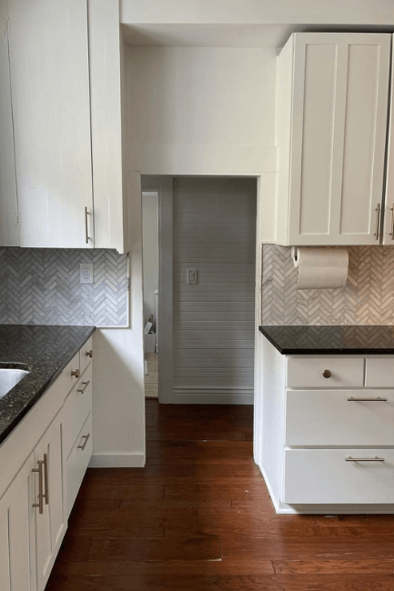 Sherwin Williams White Flour kitchen cabinets with warm wood floors.