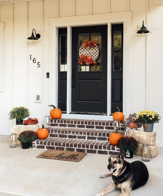 Shoji White on front porch with brick steps and pumpkins