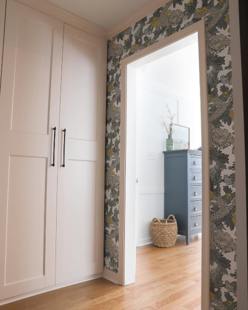 Benjamin Moore Tissue Pink in a hallway with teal wallpaper.