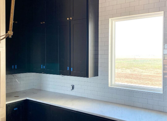 Tricorn black cabinets beside window with white tile