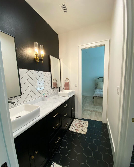 Tricorn black wall with herringbone tile and double sinks and tricorn black vanity