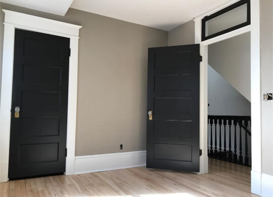 Black interior doors with white trim and greige walls