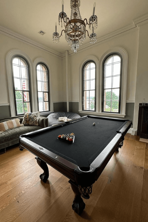 Benjamin Moore Simply White in a large living room/billiard room with cool white trim where the color looks quite warm on the walls.