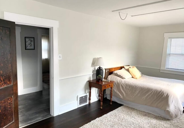 Sherwin Williams Ethereal White with Extra White trim in a bedroom with dark wood floors