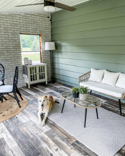 Evergreen Fog on exterior siding on one wall and brick on the other wall in an enclosed porch.