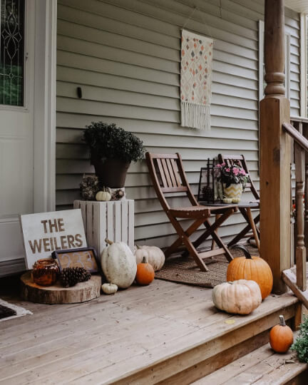 Siding similar to Evergreen Fog on a front porch with autumn decor.