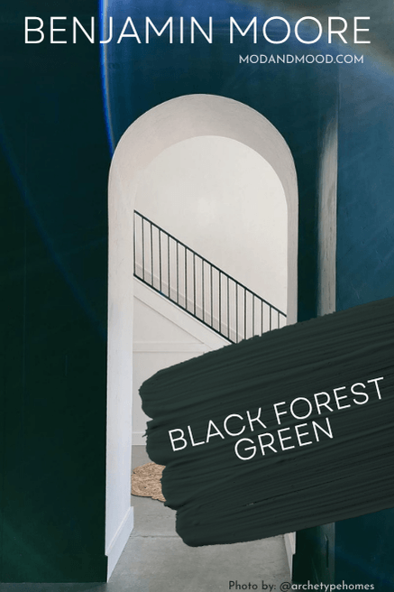 Swatch of Benjamin Moore Black Forest Green over a photo of the color on walls in a room with an arched doorway into a white room with a white staircase.