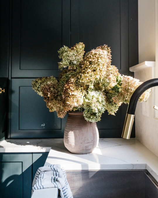 Black Forest green on wall cabinets behind a vase of flowers