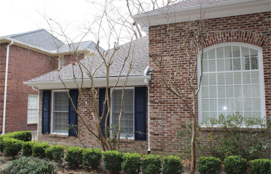 Naval shutters on a brick home with white trim