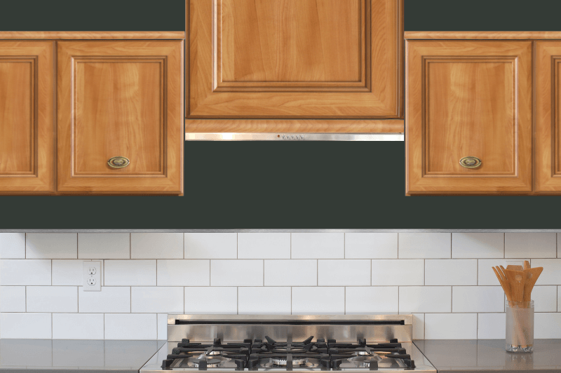 Jasper on a wall behind oak cabinets and white subway tile