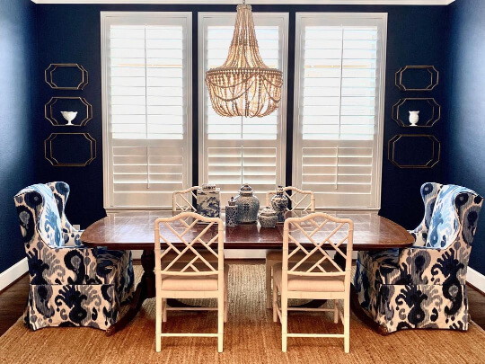 Sherwin Williams Naval in a dining room with a retro shell chandelier, long wood table and white chairs