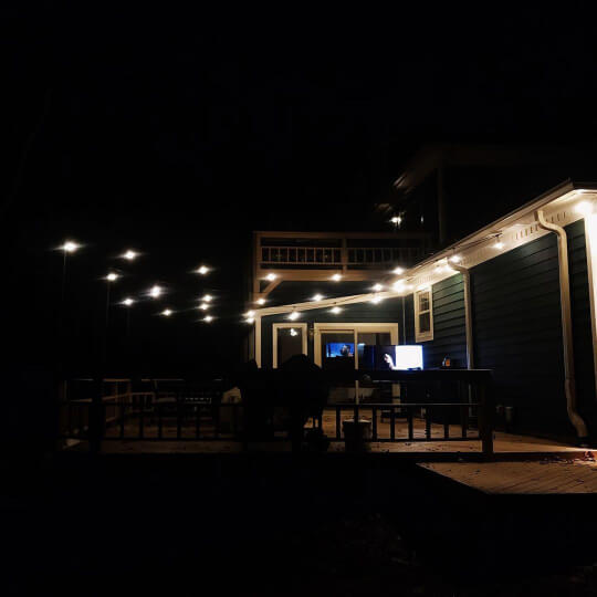 Sherwin Williams Cascades Exterior with Wool Skein trim, at night with patio lights