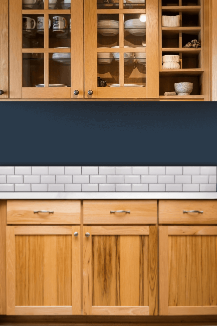 Sherwin Williams honey oak kitchen cabinets with Naval walls above subway tile.