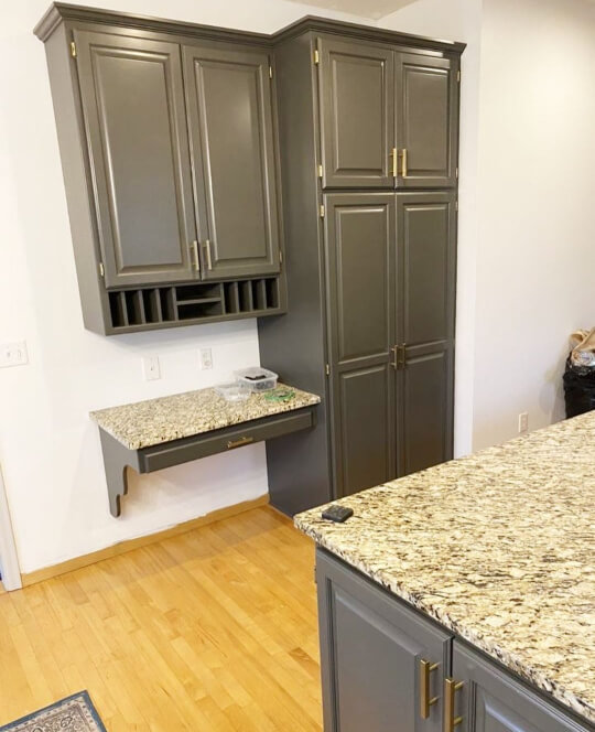 Urbane Bronze tall pantry cabinet and wine glass rack over honey oak floors