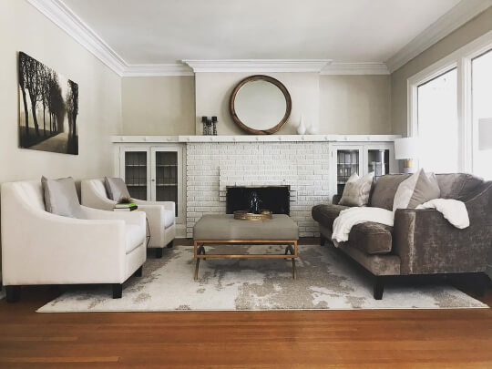 Dove Wing looks beige on the walls of a living room with Benjamin Moore Alabaster ceiling, trim, and fireplace