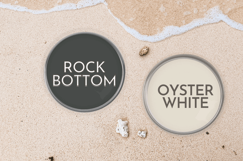 Sherwin Williams Oyster White and Rock Bottom on paint can lids on a sandy beach