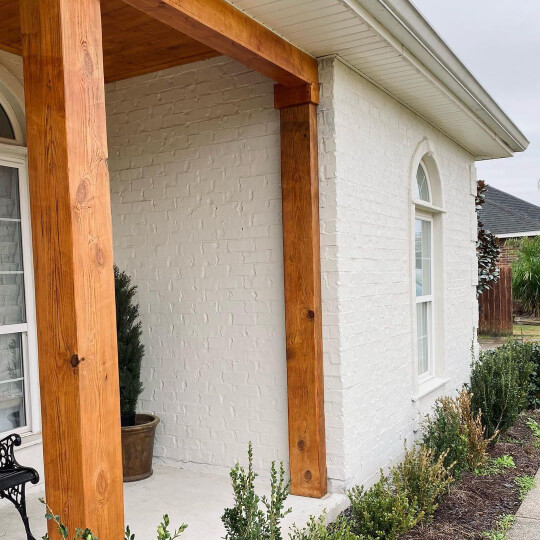 Sherwin Williams Oyster White Painted Brick exterior of a house with cedar beams and white windows