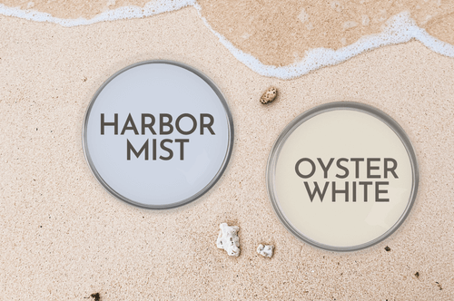 Sherwin Williams Oyster White and complementary color Harbor Mist on paint can lids on a sandy beach