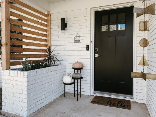 Pure white painted brick at a front entrance with tricorn black front door