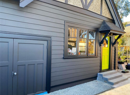 Garage side view of home exterior with Iron Ore Siding Black Trim and Lime green front door