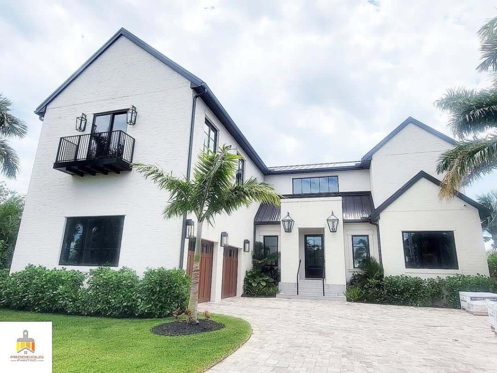 Sherwin Williams Shoji White on a large brick exterior with a double car garage with wood doors.