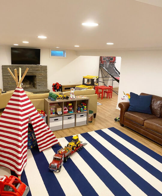 Pure White on walls and ceiling in a basement with a bold striped rug and children's tent in the rec room area.