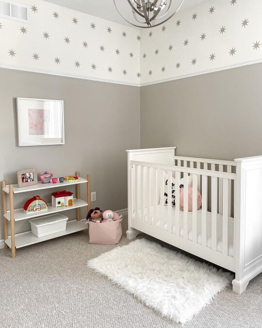 Accessible Beige 2/3 walls in a nursery with white star print on top 1/3. A white crib and shelves line the room