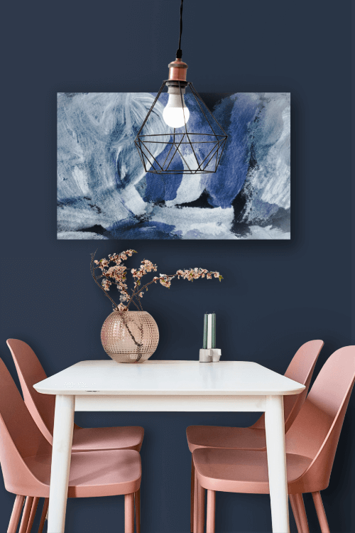 Benjamin Moore Deep Royal in a dining room with a white table and pink chairs and blue art on the wall.
