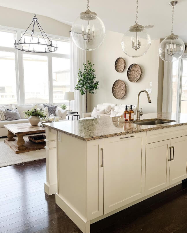 Linen colored kitchen island looking into an accessible beige living room and dining room
