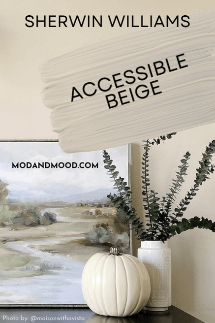 Swatch of Accessible Beige over the color on a wall with a calm landscape painting and neutral decor items.