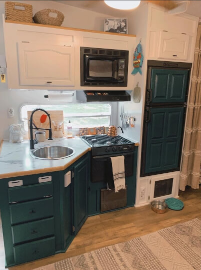 Lower cabinets and fridge door painted in sherwin Williams Blue peacock, with white upper cabinets