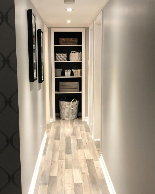 Behr Silver Bullet in a long well lit hallway with wood floors and white trim