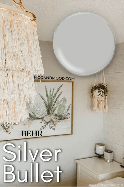 Swatch of Behr Silver Bullet over a backgrund of the color in a living room