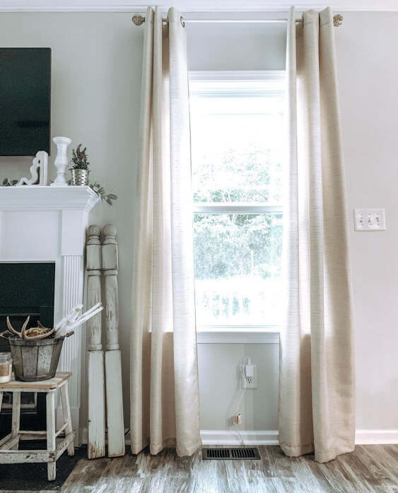 Behr Silver Drop on a living room wall. Window with a floor length silky beige curtains. 