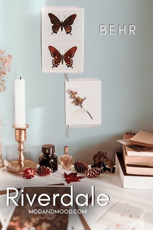 Behr Riverdale color on a wall behind boho art and a scattered desk