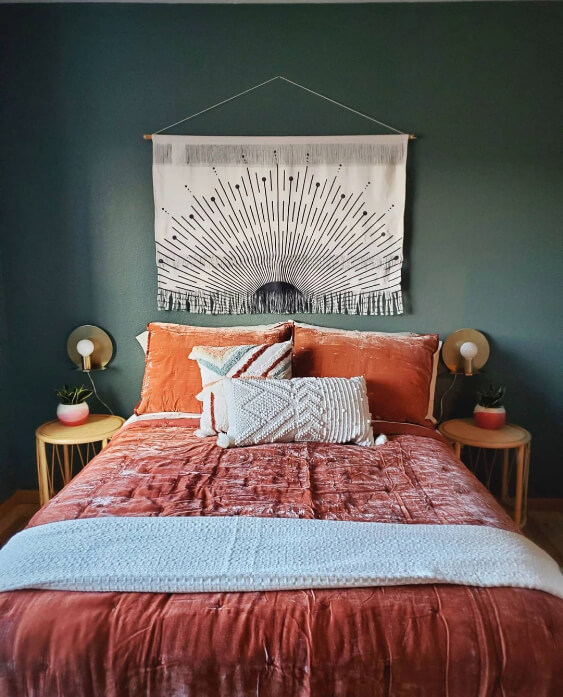 Sherwin Williams Succulent on the walls in a bedroom behind a boho wall hanging with rust colored crushed velvet bedding