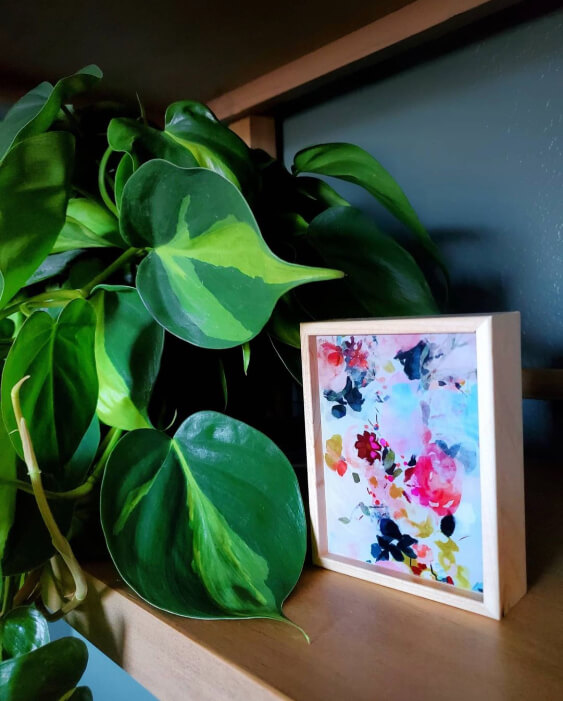 Close up of Sherwin Williams Succulent on a wall behind a plant and a floral watercolor
