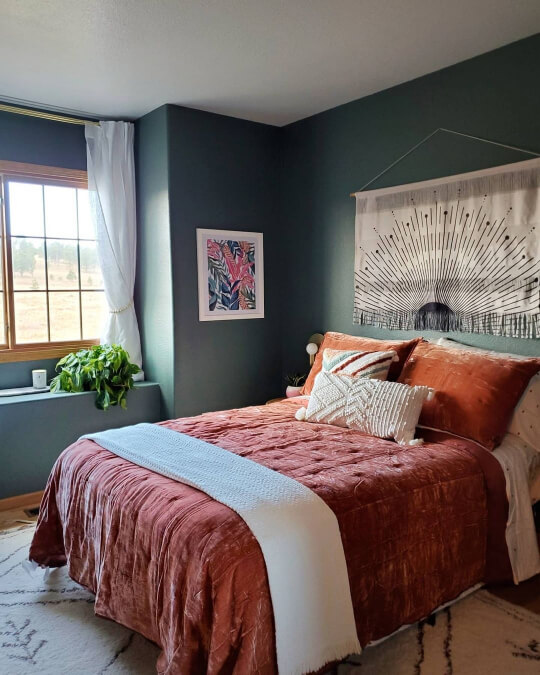 Sherwin Williams Succulent on bedroom walls with a bed that has rust colored bedding.