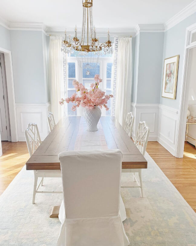 Light French Gray looks like a soft baby blue in a dining room with white wainscoting on the lower part of the wall and honey oak floors