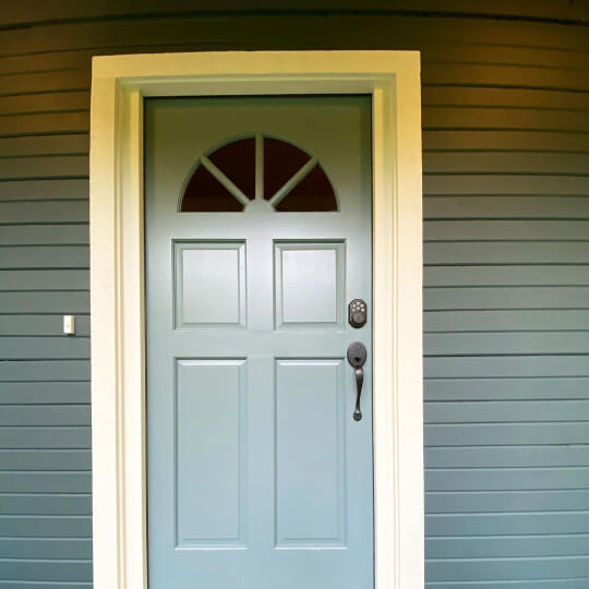 Benjamin Moore Tapestry Beige - a darker cream color -  on the trim around a steepcliff gray front door with Benjamin Moore dark pewter on the exterior siding
