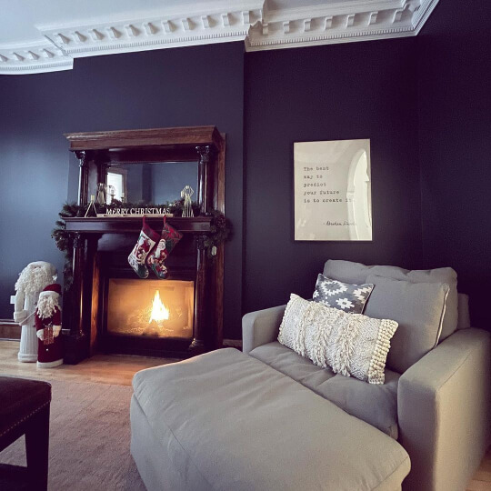 Benjamin Moore Soot on a living room wall in a Victorian home with a dark wood fireplace, white crown moulding, and a light gray overstuffed chair